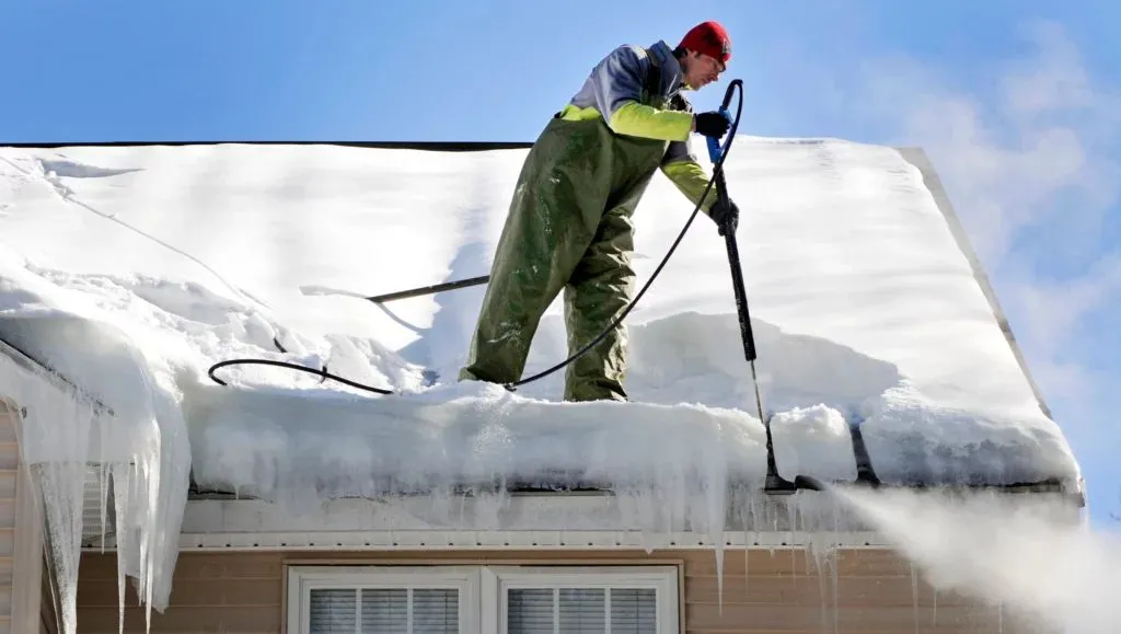 Alaska Heat Cable crew steaming an ice dam off a roof edge