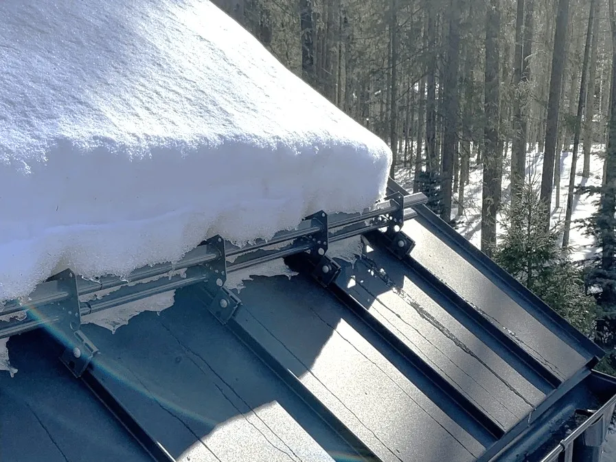 Snow guard rails on a standing seam metal roof holding back a deep snowpack