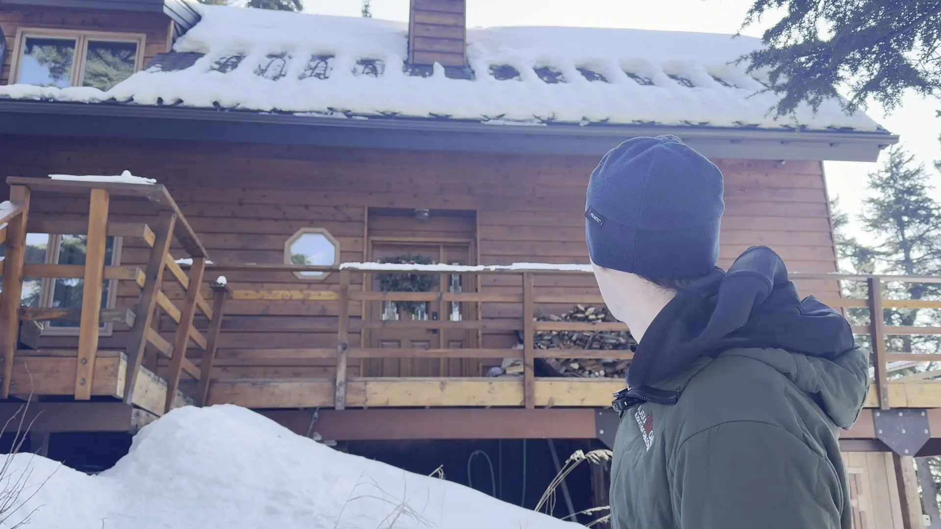 Luke, owner of Alaska Heat Cable, looking up at a snowy cabin roof