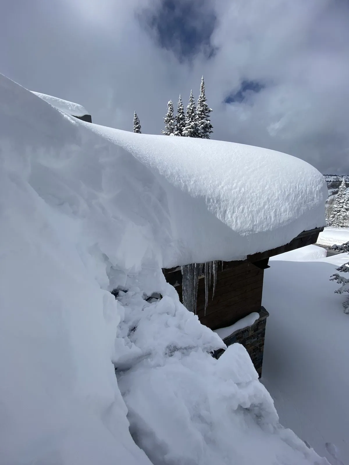 Heavy ice and icicles overhanging the eave of an Anchorage home