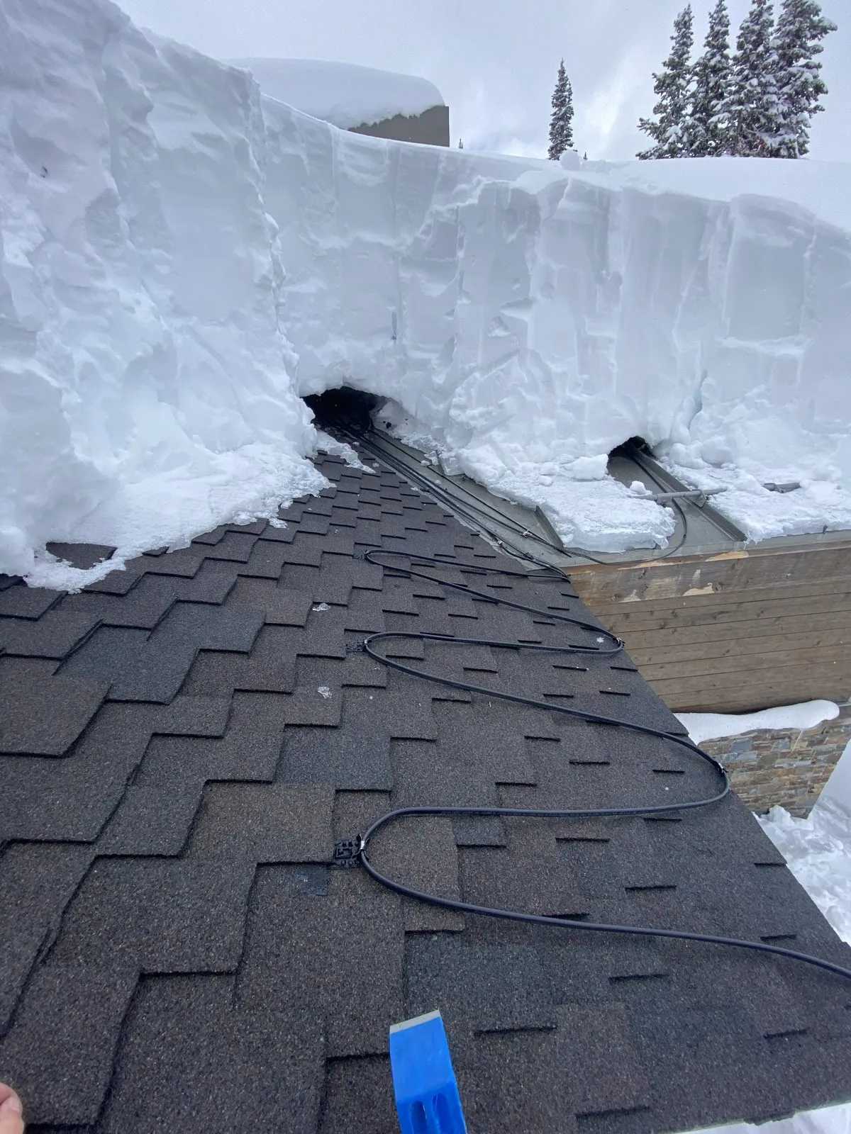 A heavy snow slab creeping over a roof edge in Anchorage